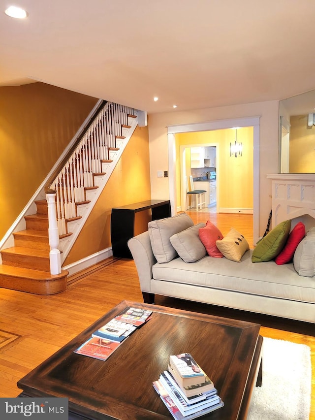 living area with stairs, recessed lighting, wood finished floors, and baseboards