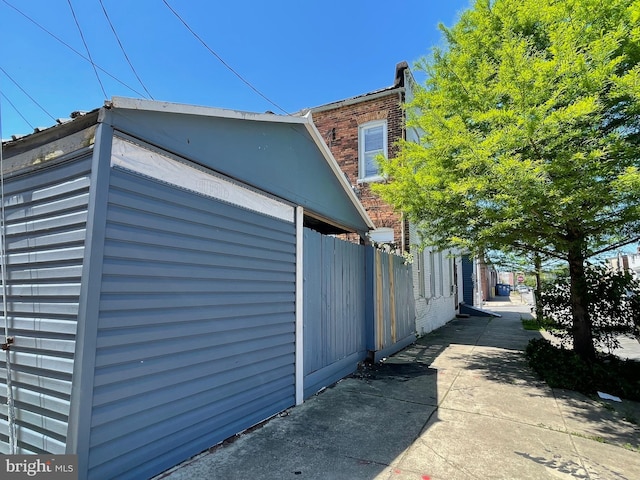 view of property exterior featuring fence and brick siding
