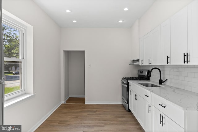 1294 Chase St, Camden, NJ 08104 - kitchen featuring stainless steel range with gas cooktop, a sink, under cabinet range hood, healthy amount of natural light, and recessed lighting