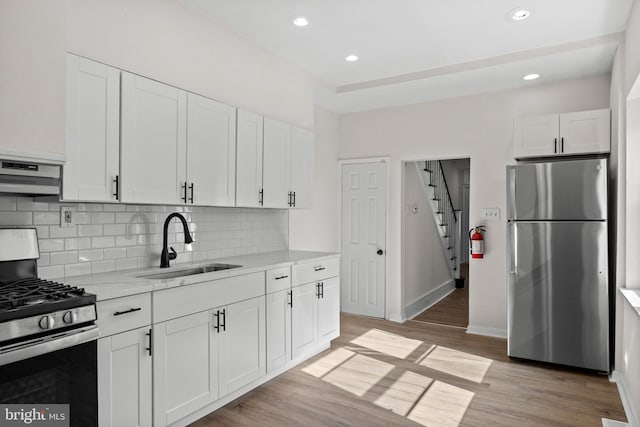 1294 Chase St, Camden, NJ 08104 - kitchen with appliances with stainless steel finishes, a sink, exhaust hood, backsplash, and white cabinets