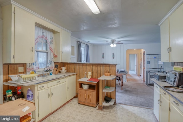 85 Woodland Ave, Ocean View, DE 19970 - kitchen featuring a sink, arched walkways, light countertops, ceiling fan, and light colored carpet