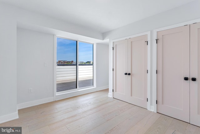 845 19th St NE Unit Ph-12, Washington, DC 20002 - unfurnished bedroom featuring two closets, light wood-style flooring, and baseboards