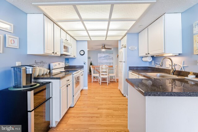 9900 Coastal Hwy Unit 1903, Ocean City, MD 21842 - kitchen with white appliances, a sink, a ceiling fan, light wood-type flooring, and white cabinets