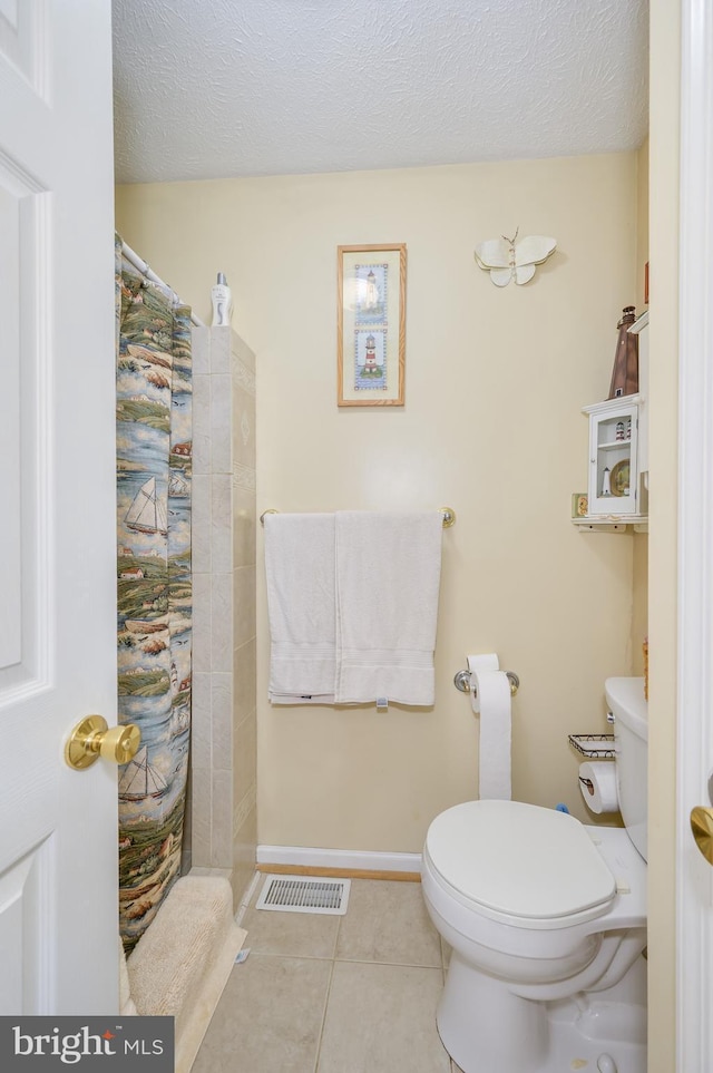523 Zig Zag Ln, Inwood, WV 25428 - full bath featuring toilet, tile patterned flooring, a tile shower, a textured ceiling, and baseboards