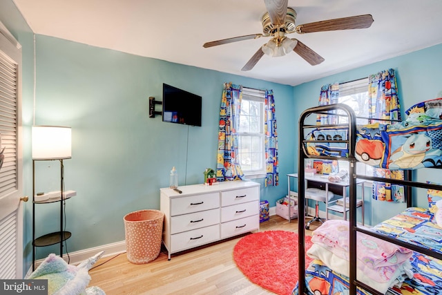 bedroom featuring light wood-type flooring, baseboards, and ceiling fan
