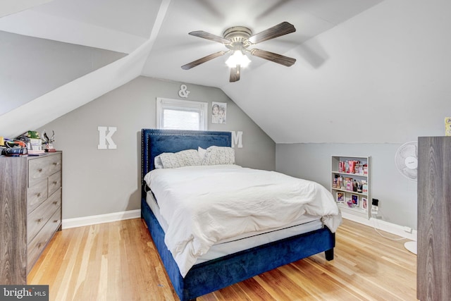 bedroom featuring wood finished floors, baseboards, lofted ceiling, and ceiling fan