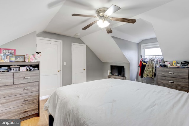 bedroom with wood finished floors, vaulted ceiling, and a ceiling fan