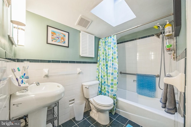 329 Dickinson Ave, Swarthmore, PA 19081 - full bathroom with tile walls, toilet, shower / bath combination with curtain, tile patterned flooring, and a skylight