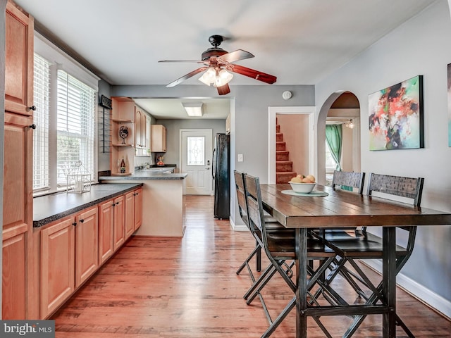 3932 Glenhurst Rd, Baltimore, MD 21222 - dining area with a ceiling fan, light wood finished floors, arched walkways, and stairway