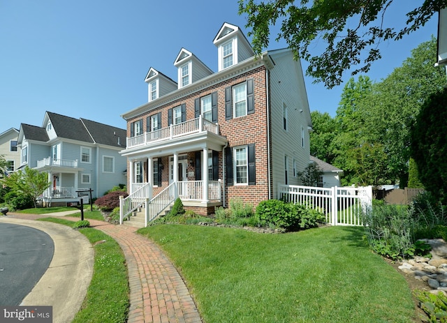 colonial home with a balcony, brick siding, and covered porch