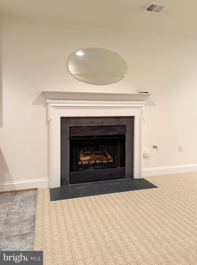 detailed view of a fireplace with flush hearth, baseboards, and carpet