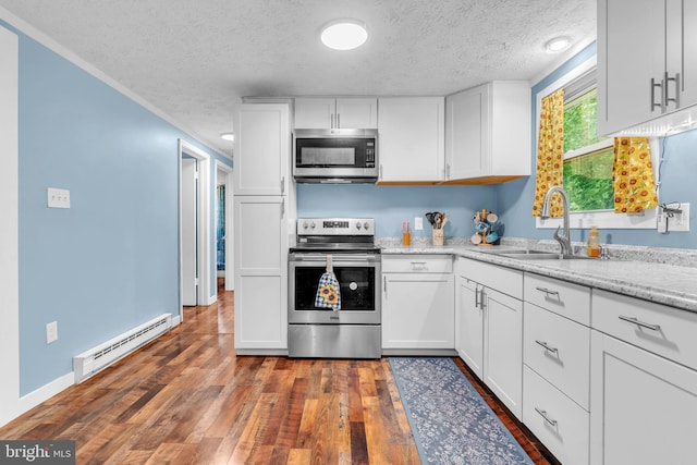 7570 Independence Cir, Charlotte Hall, MD 20622 - kitchen featuring appliances with stainless steel finishes, baseboard heating, a sink, a textured ceiling, and white cabinets