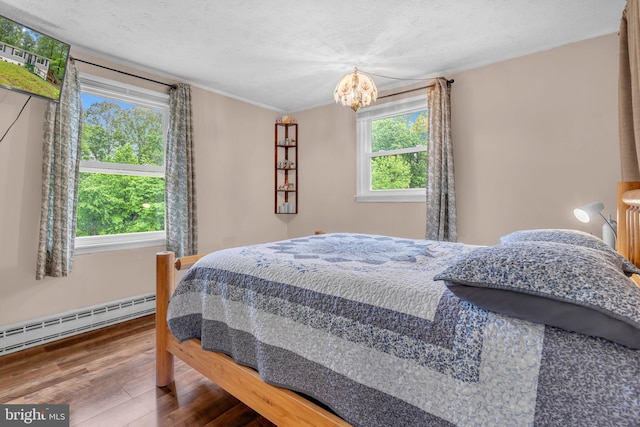 7570 Independence Cir, Charlotte Hall, MD 20622 - bedroom with a baseboard radiator, multiple windows, hardwood / wood-style flooring, a chandelier, and ornamental molding