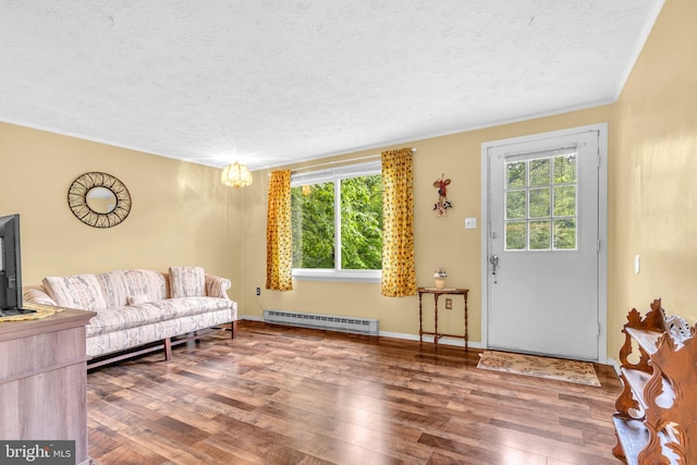 7570 Independence Cir, Charlotte Hall, MD 20622 - living room featuring a baseboard radiator, a textured ceiling, healthy amount of natural light, wood finished floors, and ornamental molding