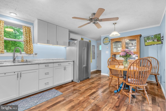 7570 Independence Cir, Charlotte Hall, MD 20622 - kitchen with freestanding refrigerator, a sink, light wood-style flooring, a textured ceiling, and white cabinets