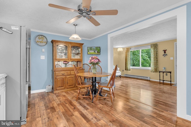7570 Independence Cir, Charlotte Hall, MD 20622 - dining area with a baseboard radiator, light wood-type flooring, a ceiling fan, a textured ceiling, and baseboards