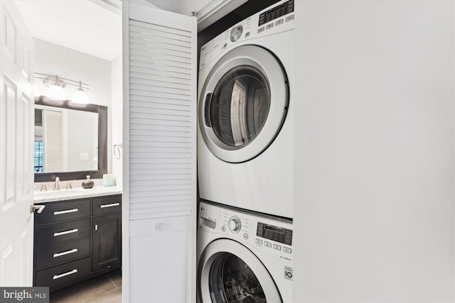 washroom featuring stacked washer and clothes dryer and light tile patterned flooring