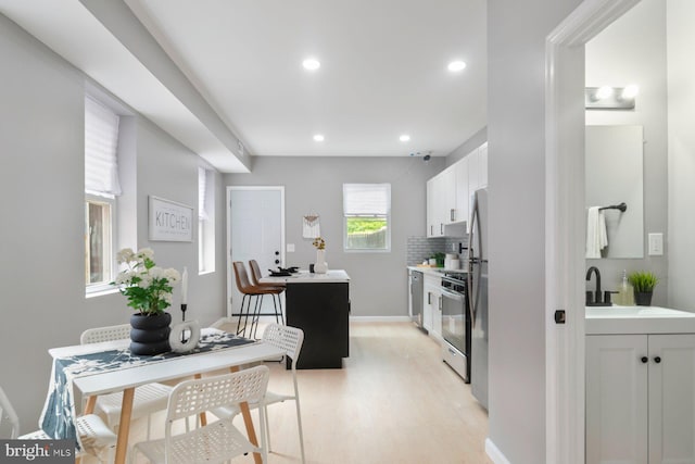 kitchen featuring gas stove, light wood-style floors, white cabinetry, recessed lighting, and dishwasher