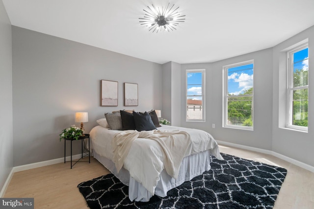 bedroom with baseboards and wood finished floors