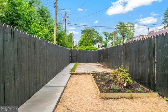 fenced backyard with a garden and a patio area