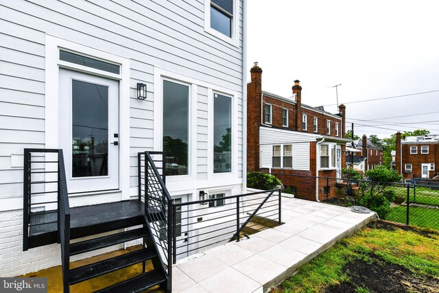 entrance to property with fence and a patio area
