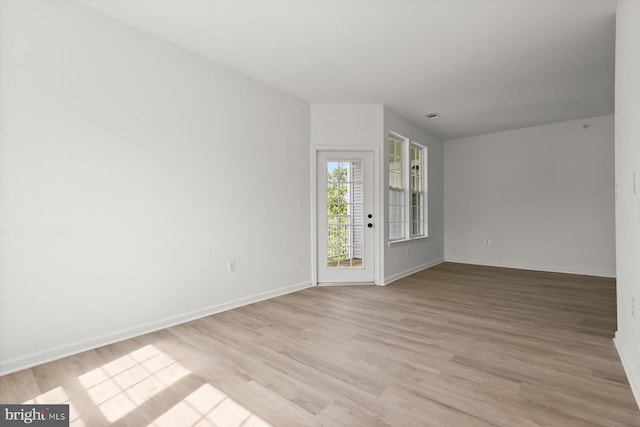 empty room with light wood finished floors and baseboards