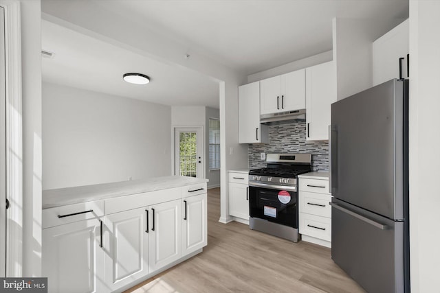 kitchen with stainless steel appliances, under cabinet range hood, light countertops, white cabinetry, and decorative backsplash