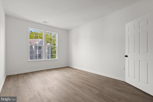 spare room featuring wood finished floors and baseboards