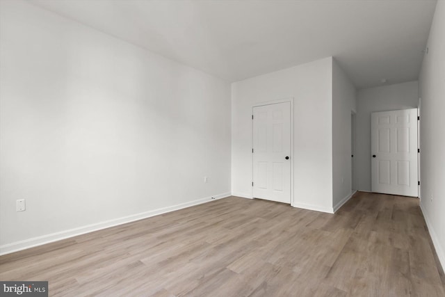 unfurnished bedroom with light wood finished floors and baseboards