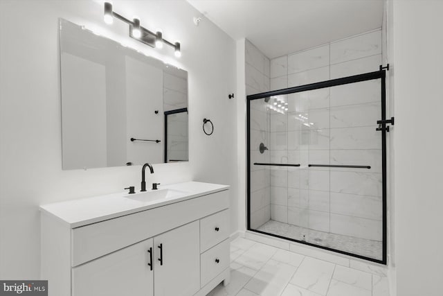 bathroom with marble finish floors, a stall shower, and vanity