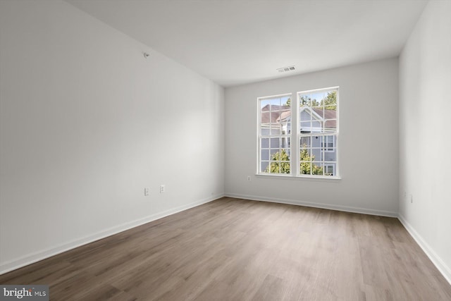 spare room with wood finished floors and baseboards