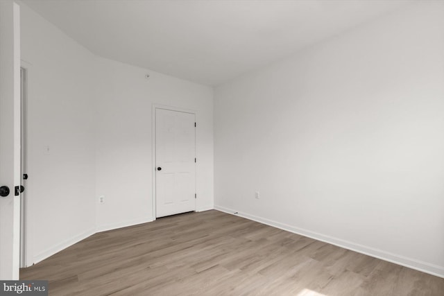 empty room featuring light wood-style flooring and baseboards