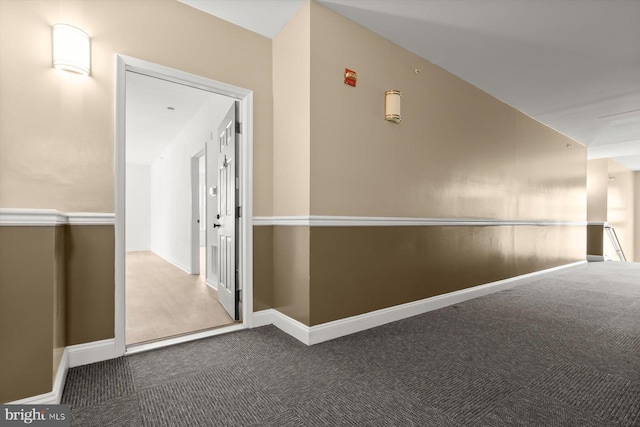 corridor featuring carpet floors and baseboards