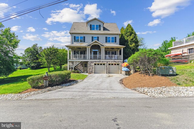 coastal inspired home with stairs, asphalt driveway, covered porch, an attached garage, and a front lawn