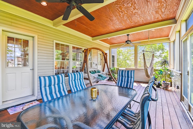 sunroom / solarium featuring a ceiling fan, outdoor dining area, beam ceiling, and plenty of natural light