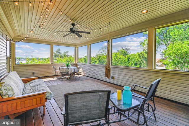 sunroom / solarium featuring track lighting, a ceiling fan, and healthy amount of natural light