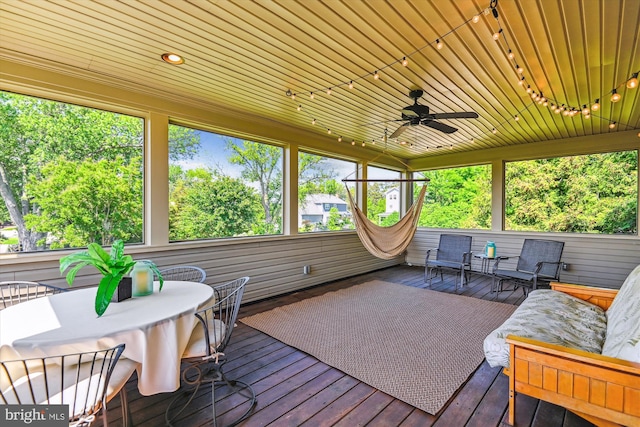 sunroom / solarium with ceiling fan, outdoor dining space, and track lighting