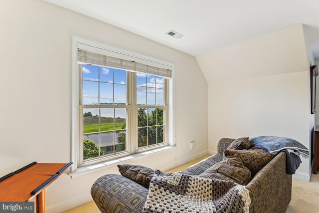 living room with light colored carpet, vaulted ceiling, and baseboards