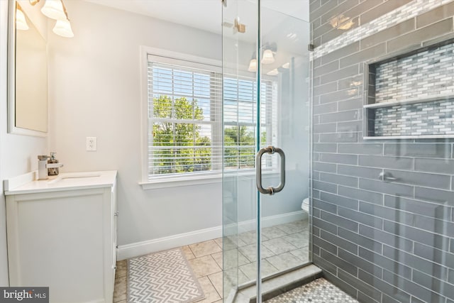 full bathroom with a stall shower, baseboards, vanity, and toilet