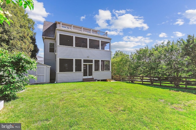 rear view of house featuring a sunroom, a storage unit, an outdoor structure, and entry steps