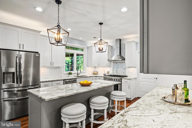 9609 Low Meadow Dr, Gaithersburg, MD 20882 - kitchen with stainless steel appliances, wall chimney exhaust hood, dark wood-style flooring, light stone countertops, and a breakfast bar area