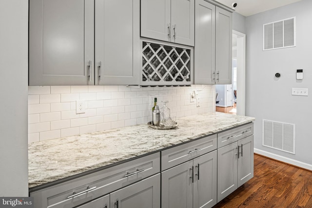 9609 Low Meadow Dr, Gaithersburg, MD 20882 - kitchen featuring gray cabinetry, tasteful backsplash, dark wood finished floors, and light stone counters