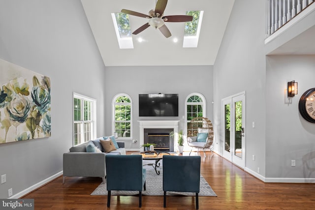 9609 Low Meadow Dr, Gaithersburg, MD 20882 - living area with high vaulted ceiling, a glass covered fireplace, healthy amount of natural light, a ceiling fan, and wood finished floors