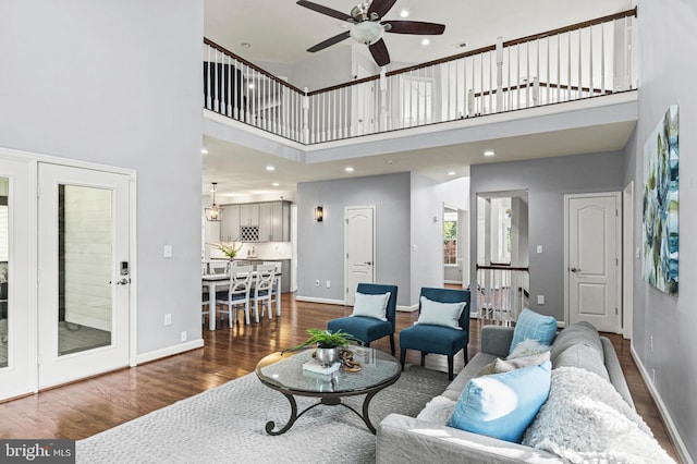 9609 Low Meadow Dr, Gaithersburg, MD 20882 - living room featuring dark wood-style flooring, a high ceiling, a ceiling fan, and baseboards