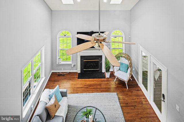 9609 Low Meadow Dr, Gaithersburg, MD 20882 - living room with a skylight, a towering ceiling, a fireplace with flush hearth, wood finished floors, and recessed lighting