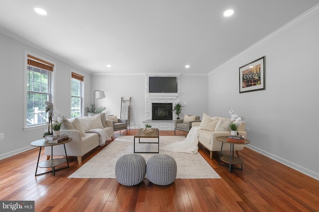 living area with a fireplace, wood-type flooring, baseboards, crown molding, and recessed lighting