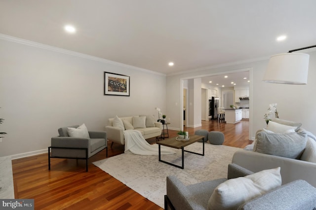 living area featuring ornamental molding, recessed lighting, wood finished floors, and baseboards