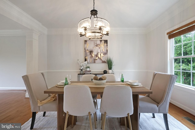 dining area featuring healthy amount of natural light, a chandelier, wood finished floors, and crown molding