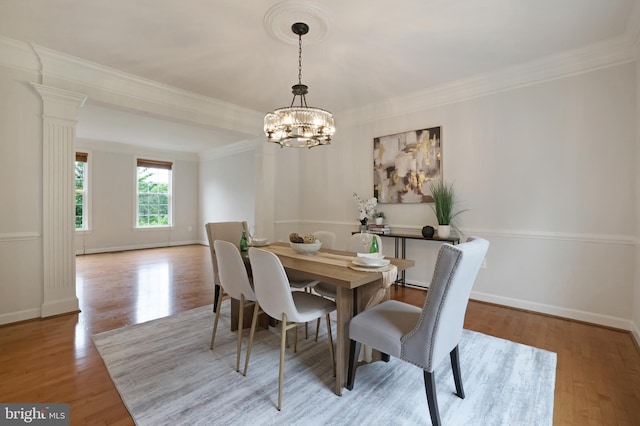 dining area featuring a chandelier, ornamental molding, wood finished floors, and baseboards