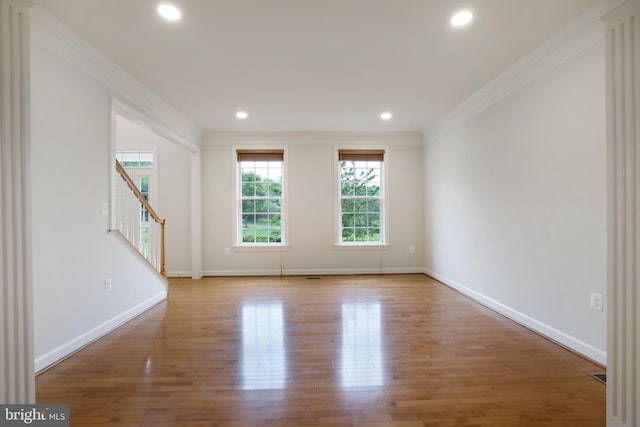 spare room featuring ornamental molding, stairway, wood finished floors, baseboards, and recessed lighting